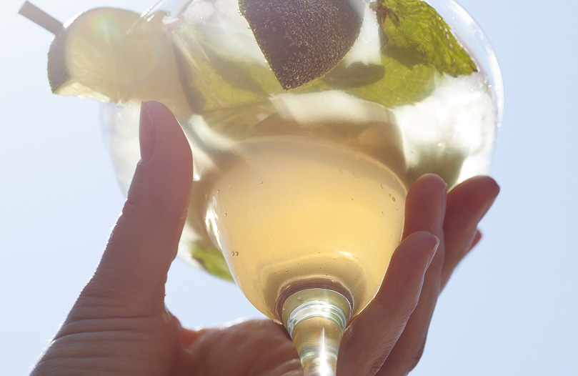 Detalle de un cocktail servido en copa y con hojas de menta