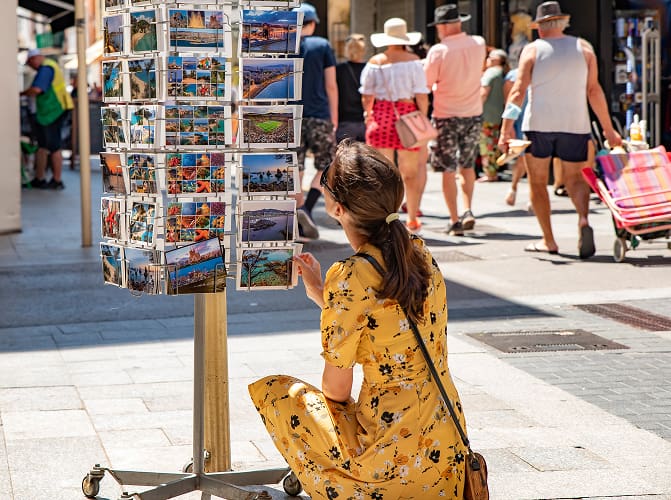 Mädchen, das sich Postkarten von Mallorca ansieht