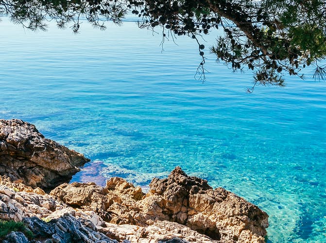 Felsen und türkisfarbenes Wasser in Cala Blanca