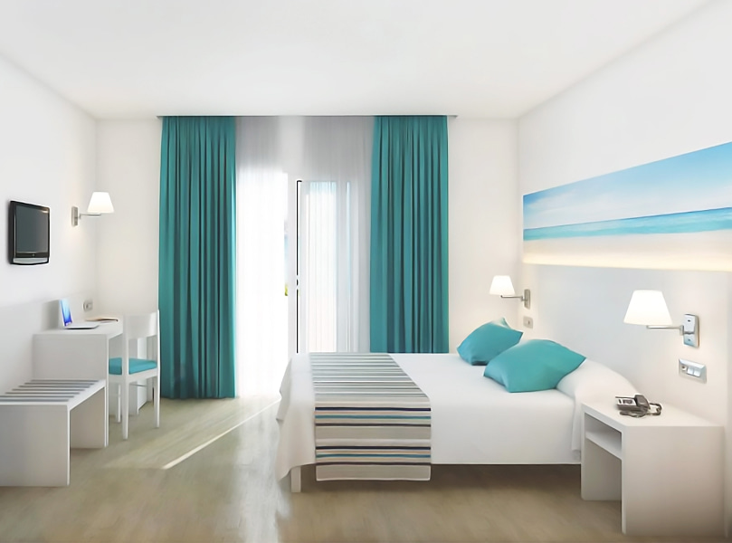 Vista Mar Lateral_General Amplia y luminosa habitación con mobiliario blanco y textiles en tonos azules.